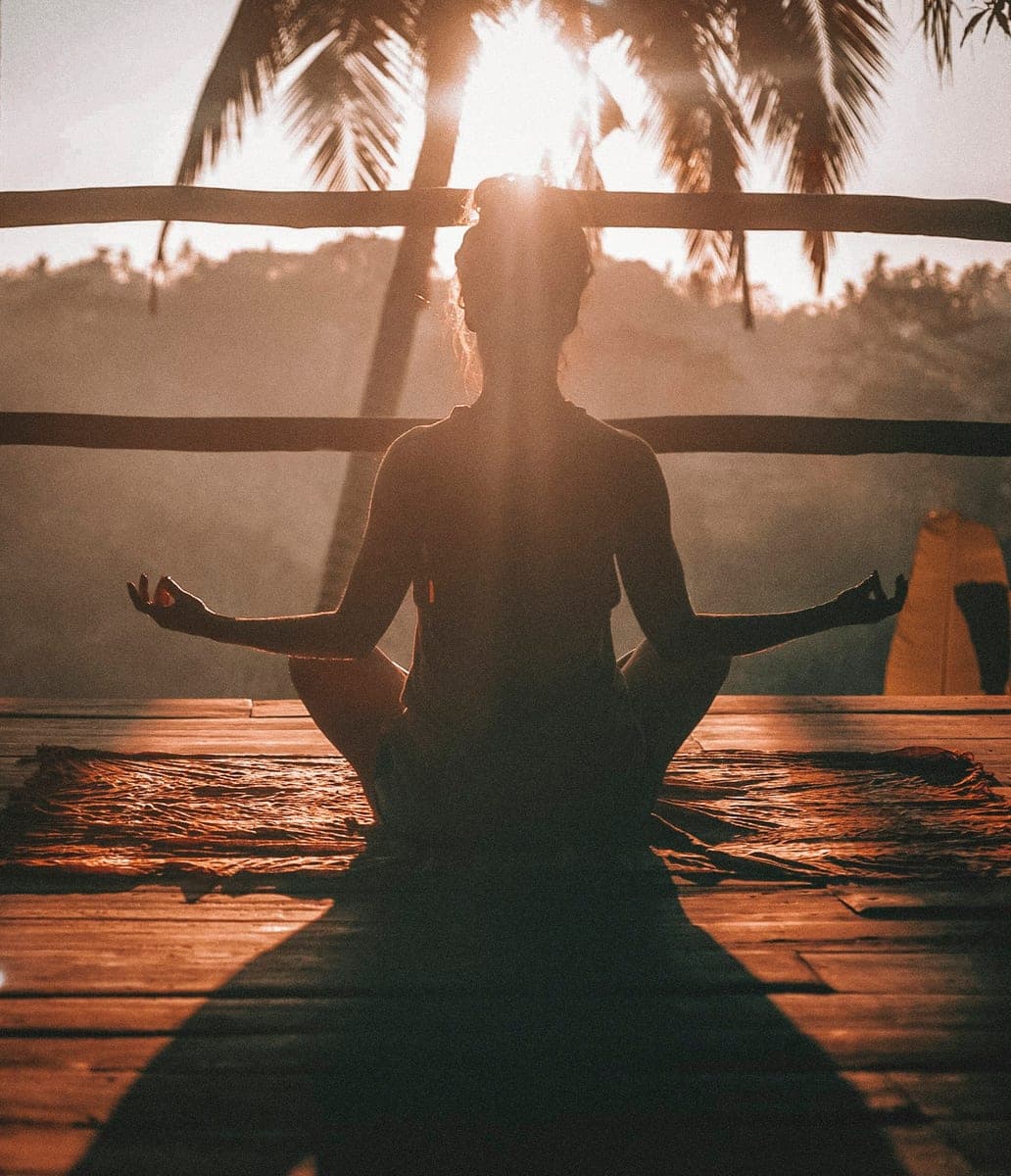 Persona meditando en calma al amanecer